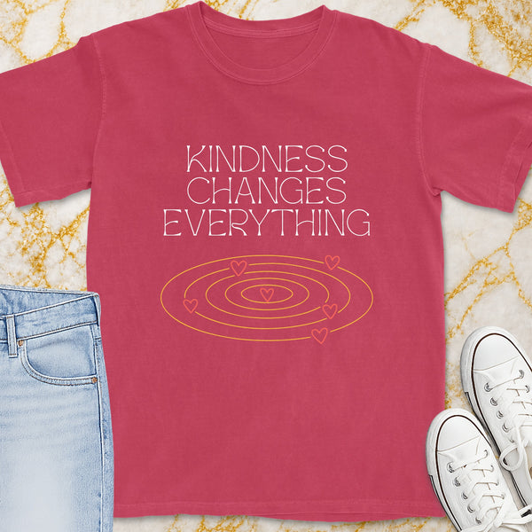 Pink t-shirt with white text "Kindness Changes Everything" and heart graphic.