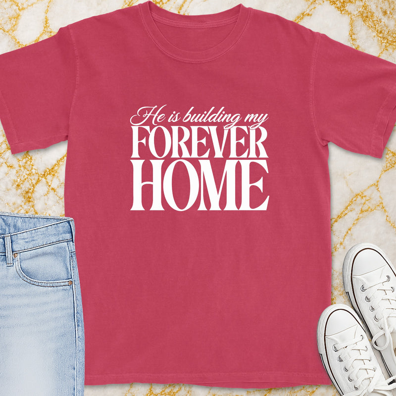 T-shirt with white text "He is building my FOREVER HOME" on a pink shirt.