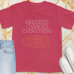 Pink t-shirt with white text "Kindness Changes Everything" and heart graphic.