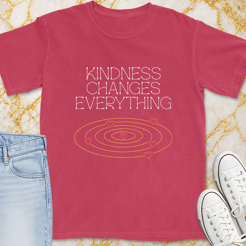 Pink t-shirt with white text "Kindness Changes Everything" and heart graphic.