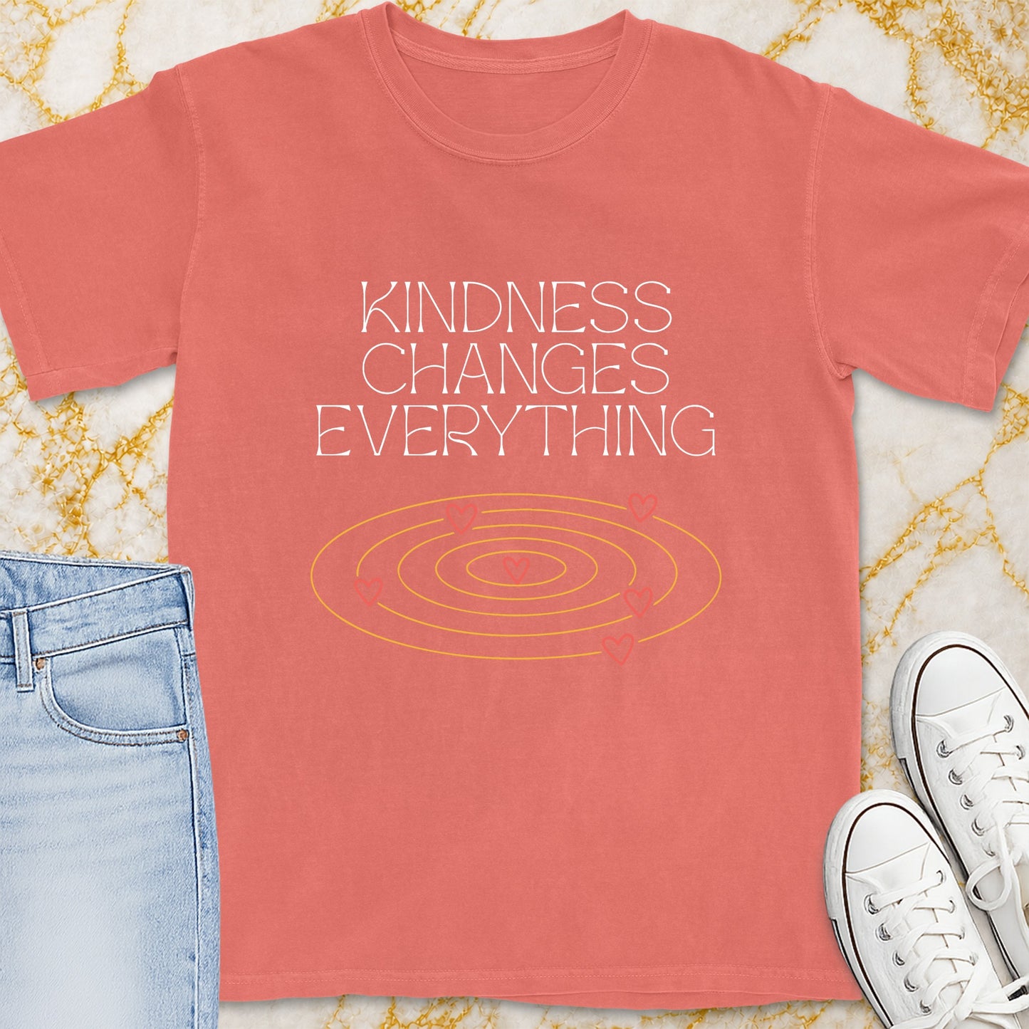 Coral t-shirt with "Kindness Changes Everything" text and heart graphic.