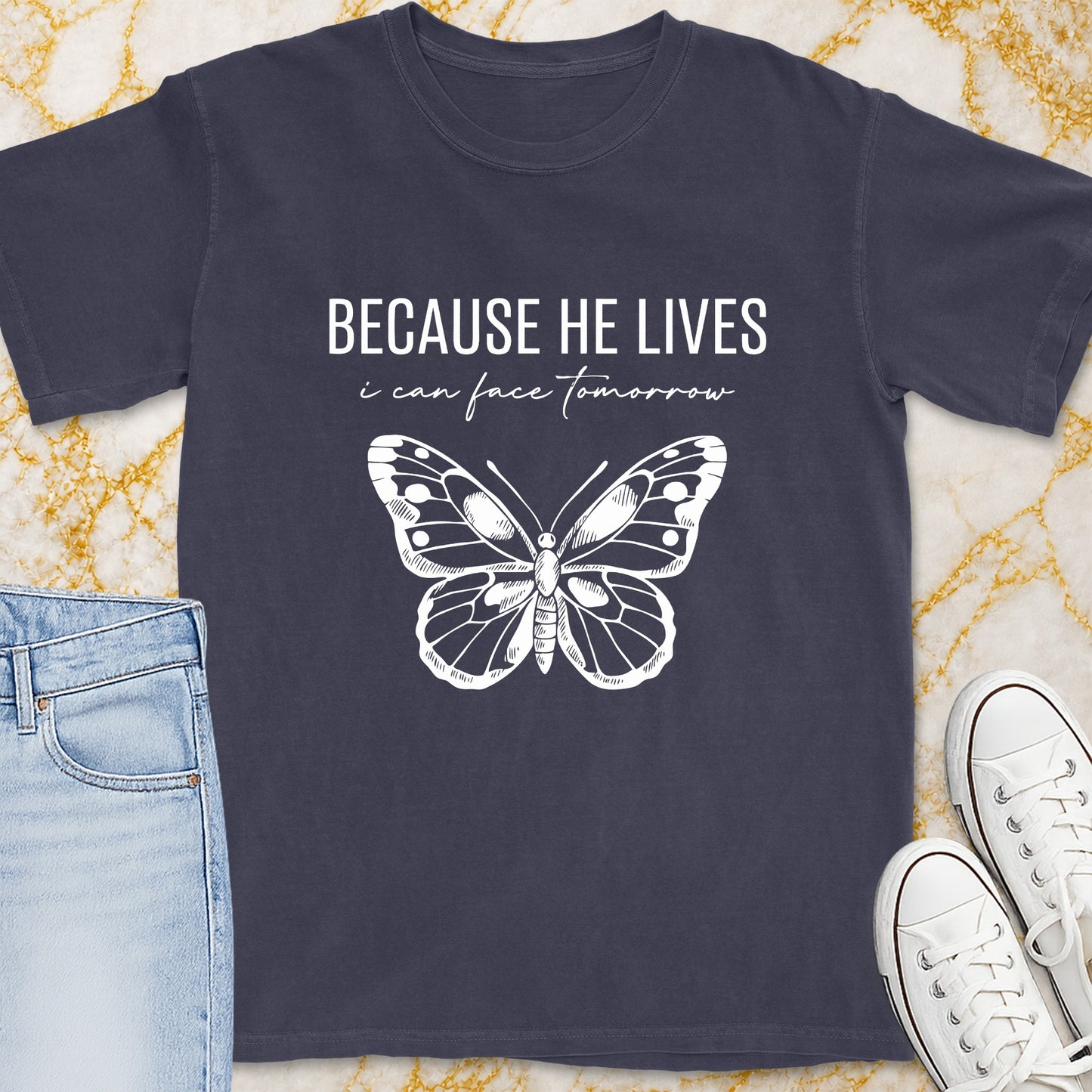 Dark grey t-shirt with white text "BECAUSE HE LIVES i can face tomorrow" and a butterfly design.