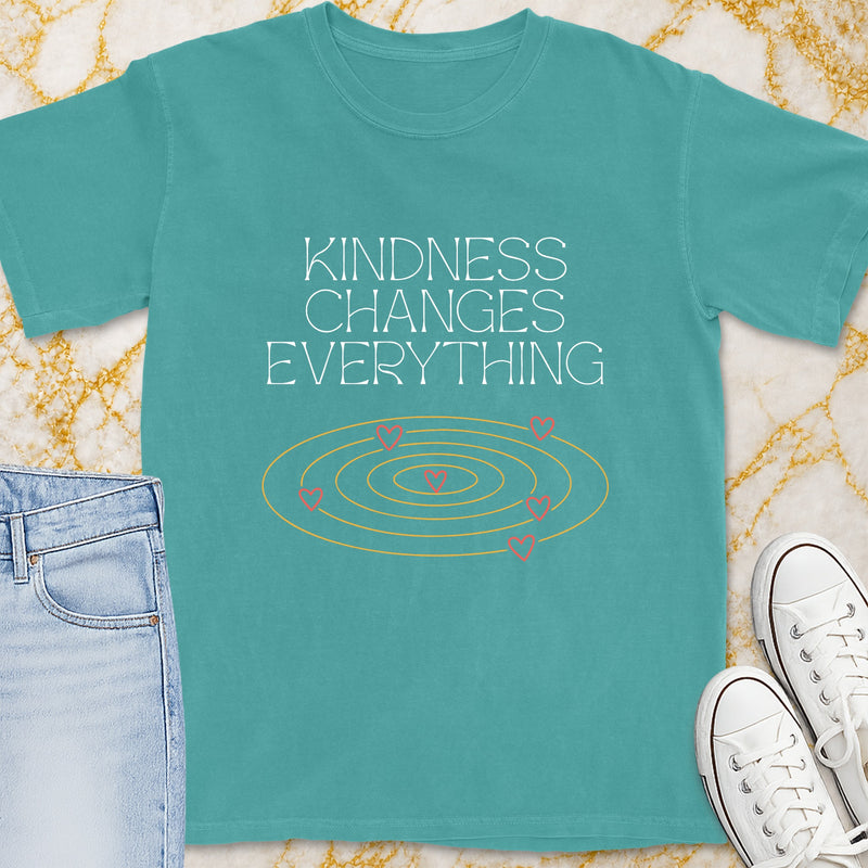 Teal t-shirt with "Kindness Changes Everything" and pink hearts in concentric circles.