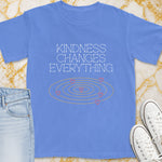 Blue t-shirt with "Kindness Changes Everything" text and swirling hearts graphic.