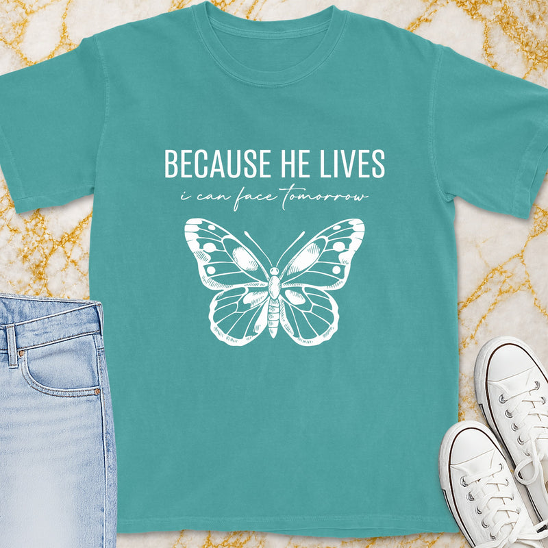 Teal t-shirt with white butterfly and text "BECAUSE HE LIVES i can face tomorrow".